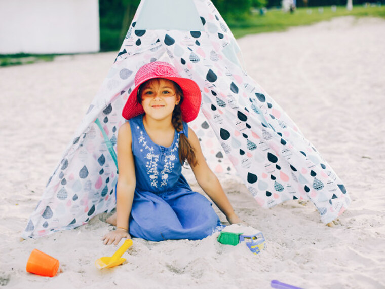 Dziewczynka bawiąca się w piasku na mini plaży